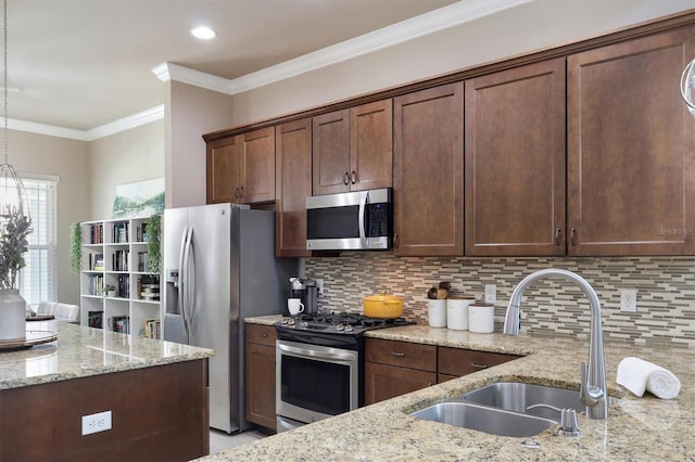 kitchen with ornamental molding, tasteful backsplash, light stone counters, a sink, and stainless steel appliances