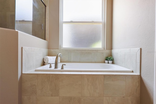 full bathroom with a textured wall, tiled shower, and a garden tub