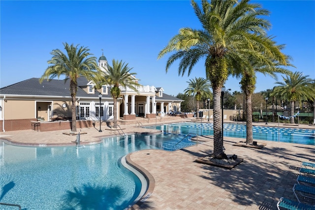 community pool featuring french doors, fence, and a patio area