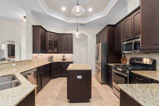 3624 SW 73rd Way, Gainesville, FL 32608 - kitchen with appliances with stainless steel finishes, arched walkways, light stone counters, decorative backsplash, and dark brown cabinetry
