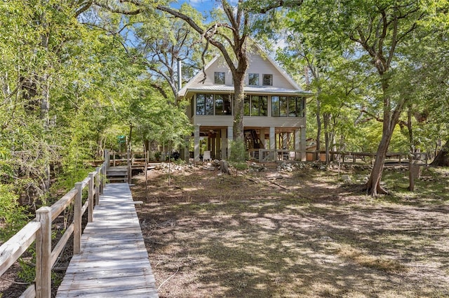 rear view of property featuring a sunroom and fence