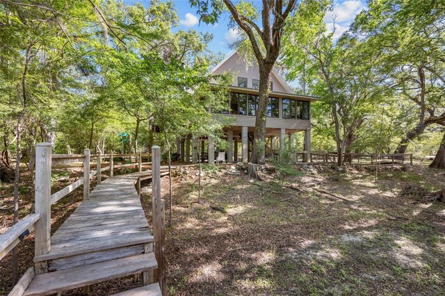 back of house featuring a sunroom and fence