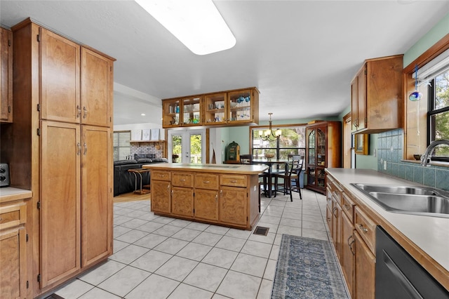 kitchen with a sink, light tile patterned flooring, a chandelier, decorative backsplash, and dishwasher