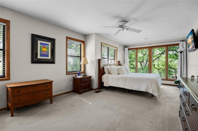 bedroom featuring light carpet, a ceiling fan, visible vents, and baseboards