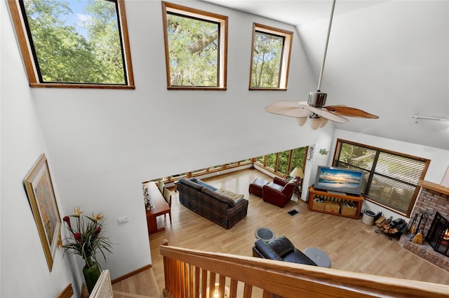 living area featuring high vaulted ceiling, ceiling fan, and wood finished floors