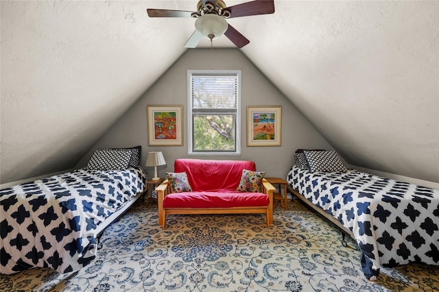 carpeted bedroom with vaulted ceiling, a textured ceiling, and a ceiling fan