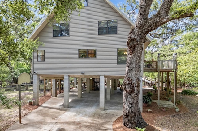 exterior space featuring concrete driveway, stairway, a carport, and a deck