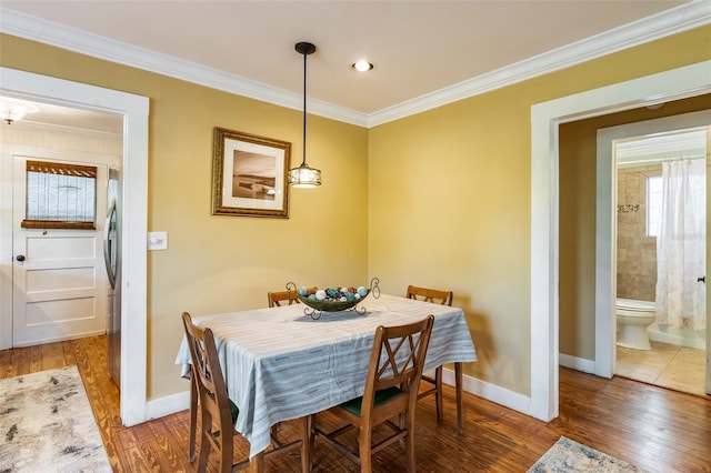 dining area with recessed lighting, wood finished floors, crown molding, and baseboards
