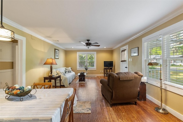 living room featuring ornamental molding, baseboards, ceiling fan, and wood-type flooring