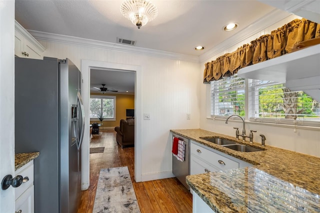 kitchen featuring a sink, stone countertops, appliances with stainless steel finishes, hardwood / wood-style floors, and ornamental molding