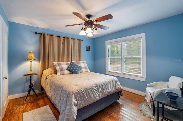 bedroom with baseboards, a ceiling fan, and wood finished floors