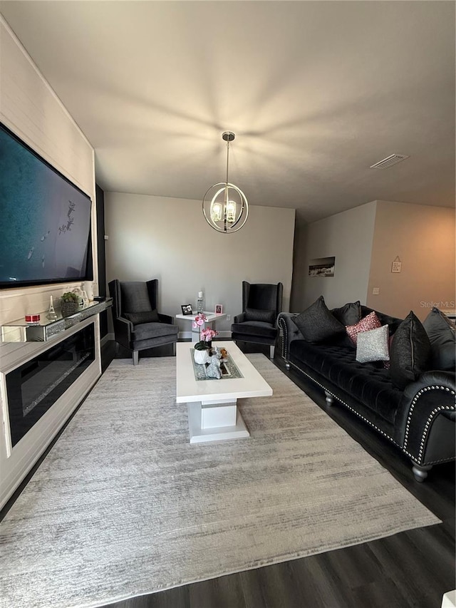 living area with wood finished floors and a notable chandelier