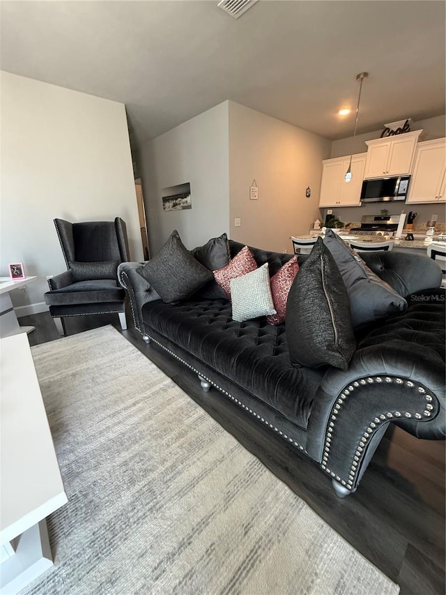 living area with wood finished floors and visible vents