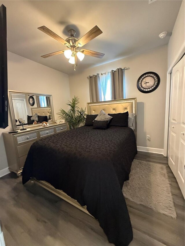 bedroom featuring a closet, dark wood-style flooring, ceiling fan, and baseboards