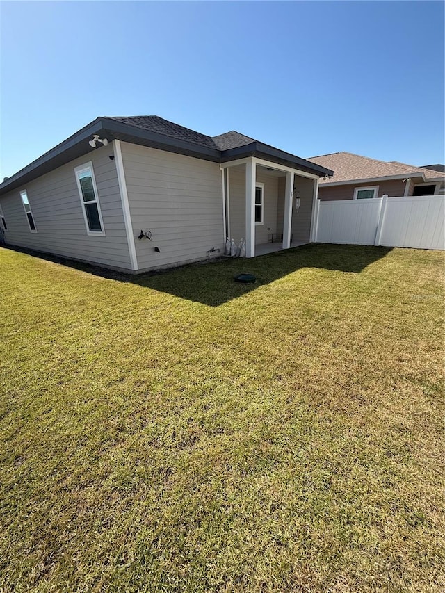 back of house with fence and a yard