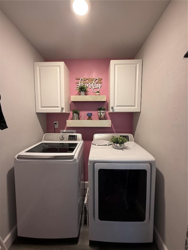 laundry area with baseboards, washer and dryer, and cabinet space