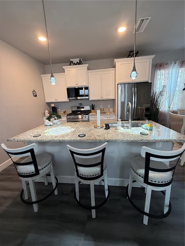 kitchen with a spacious island, visible vents, stainless steel appliances, and white cabinetry