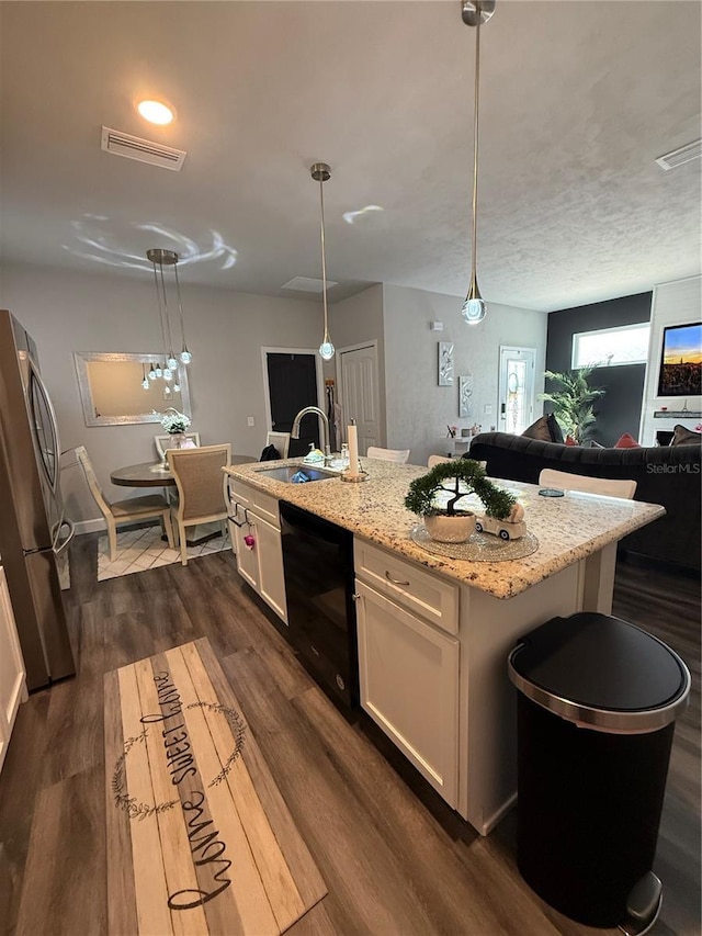 kitchen featuring white cabinets, a sink, visible vents, freestanding refrigerator, and dark wood finished floors