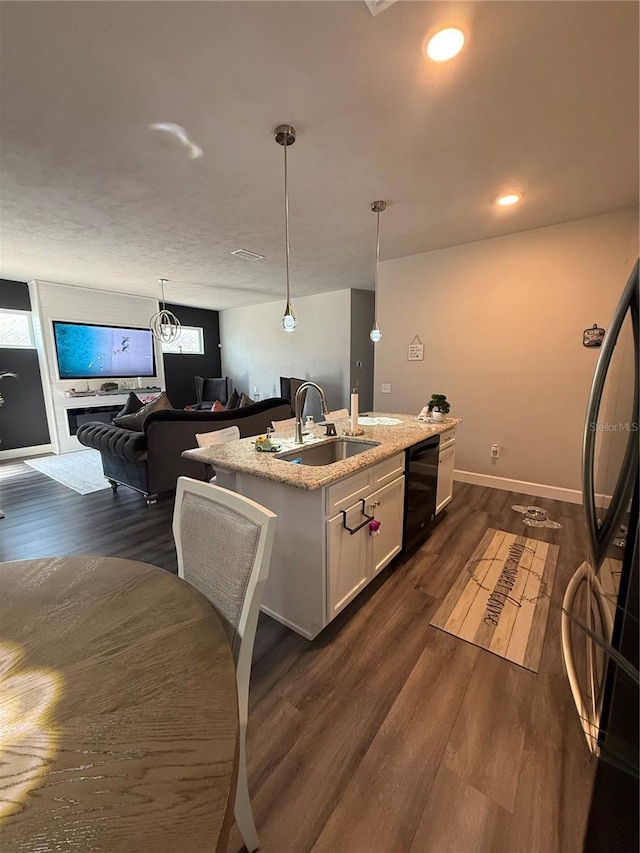 kitchen with a sink, black dishwasher, dark wood-type flooring, white cabinetry, and refrigerator