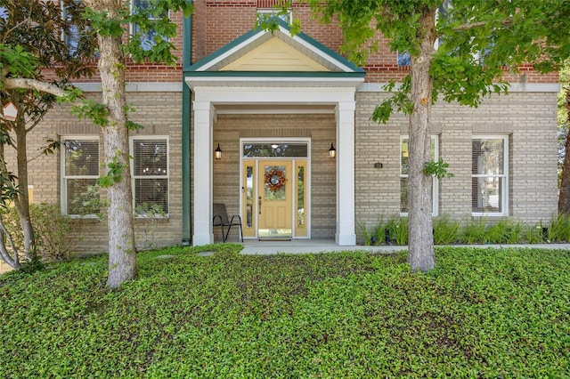 property entrance featuring brick siding