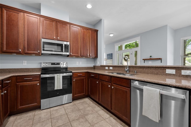 kitchen featuring stainless steel appliances, a sink, light tile patterned floors, and recessed lighting