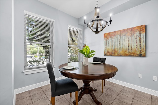 tiled dining space with a chandelier, plenty of natural light, and baseboards
