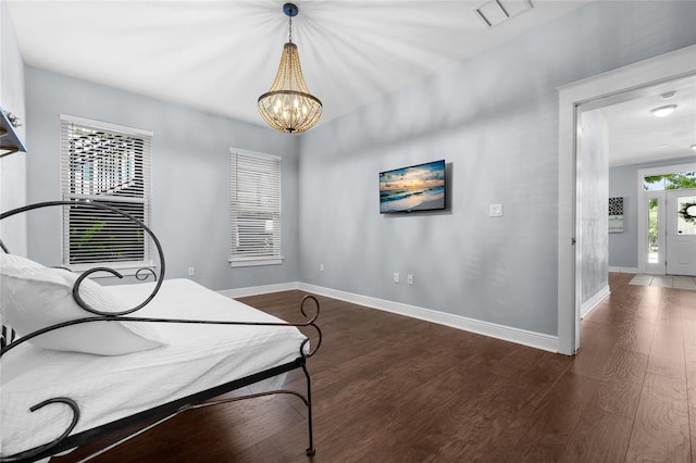 living area featuring wood finished floors, baseboards, and a chandelier