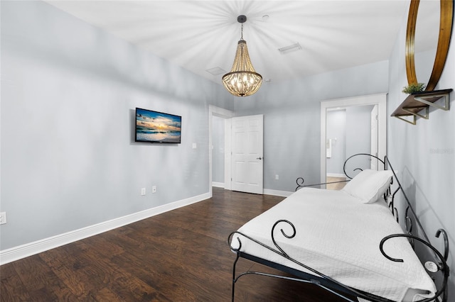 bedroom featuring a chandelier, wood finished floors, and baseboards
