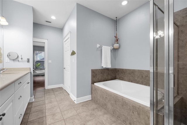bathroom with a shower stall, vanity, tile patterned floors, a garden tub, and baseboards