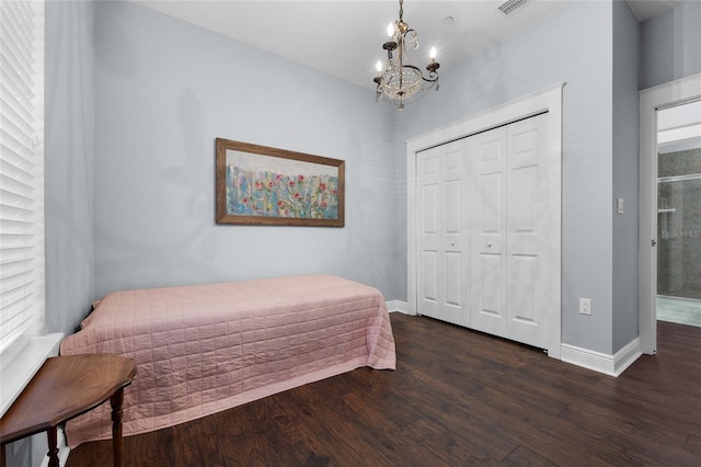 bedroom with a chandelier, dark wood-style floors, baseboards, and a closet