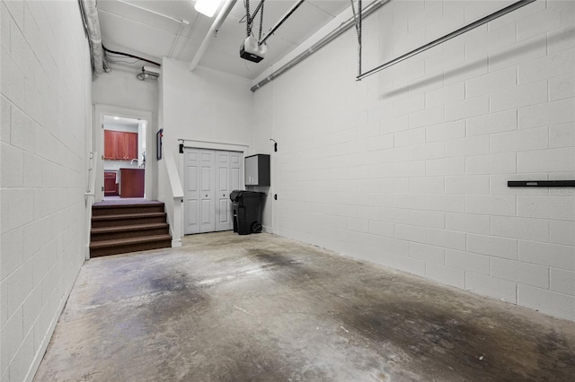 garage featuring a garage door opener and concrete block wall