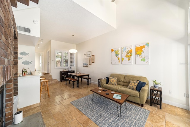 706 NE 1st St Unit 706, Gainesville, FL 32601 - living area with a fireplace, stone tile flooring, visible vents, and a high ceiling