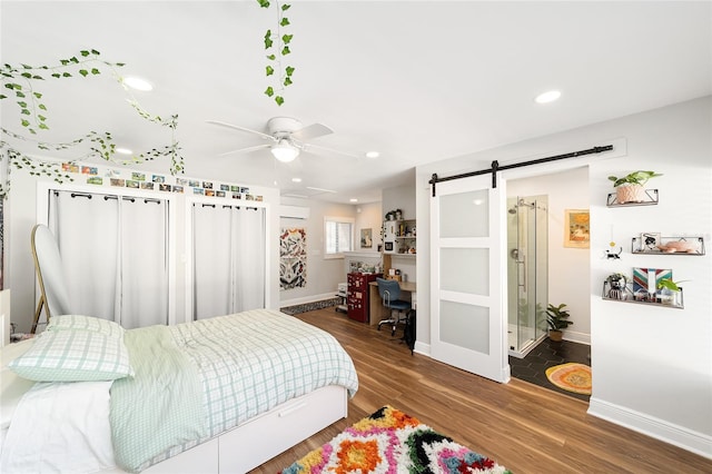 706 NE 1st St Unit 706, Gainesville, FL 32601 - bedroom with recessed lighting, wood finished floors, a barn door, ceiling fan, and baseboards