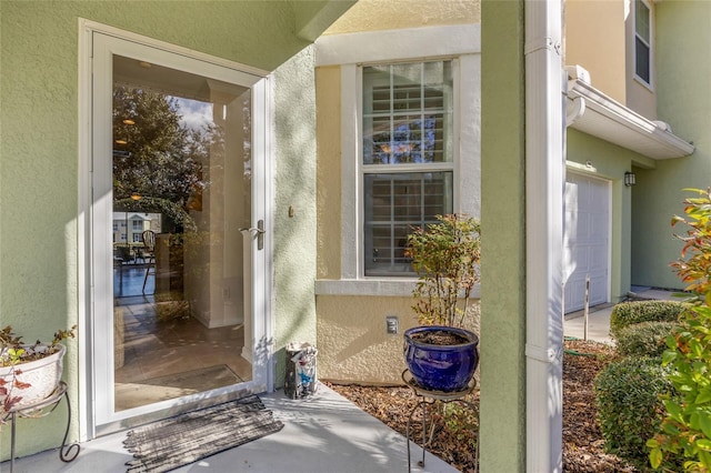 view of exterior entry with stucco siding