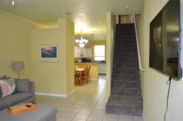 3870 SW 20th Ave Unit 1607, Gainesville, FL 32607 - living area featuring an inviting chandelier, stairs, visible vents, and light tile patterned floors