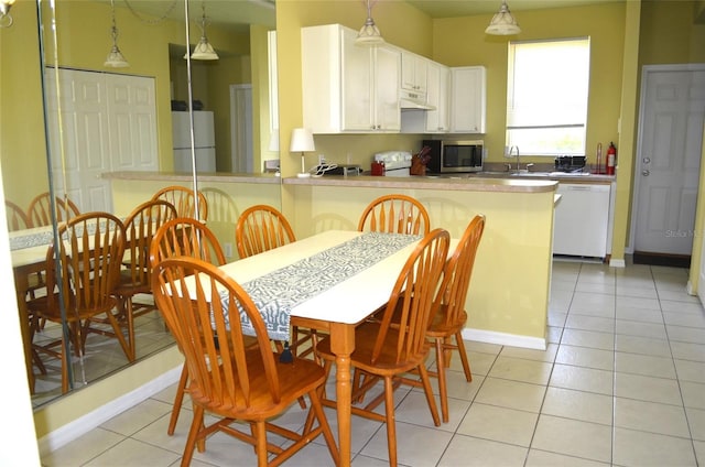 3870 SW 20th Ave Unit 1607, Gainesville, FL 32607 - kitchen featuring stainless steel microwave, freestanding refrigerator, dishwasher, and light tile patterned floors