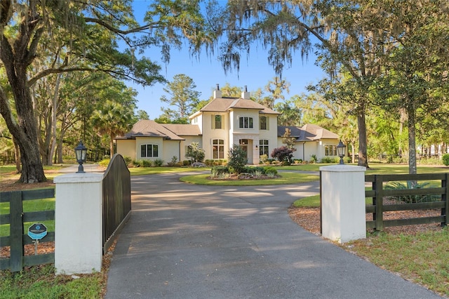 14819 NW 21st Ave, Newberry, FL 32669 - view of front of home featuring a chimney, a front lawn, curved driveway, fence, and stucco siding
