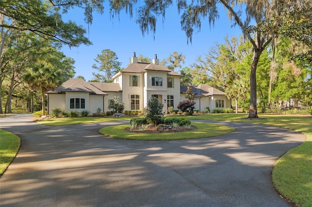 14819 NW 21st Ave, Newberry, FL 32669 - view of front of home featuring a chimney, curved driveway, and stucco siding
