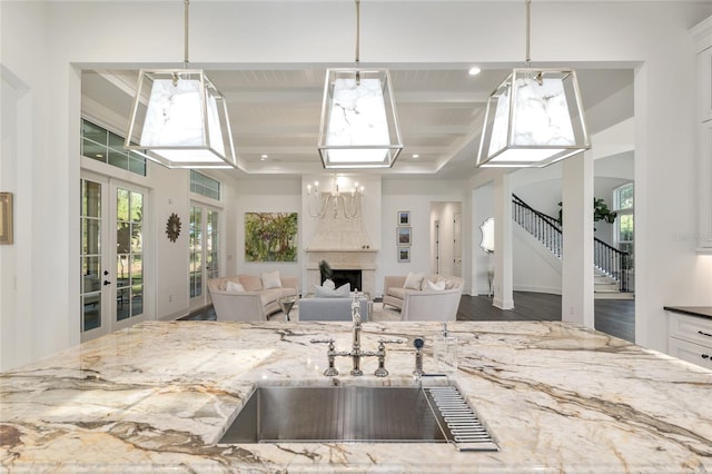 14819 NW 21st Ave, Newberry, FL 32669 - kitchen featuring light stone counters, a sink, a large fireplace, pendant lighting, and open floor plan