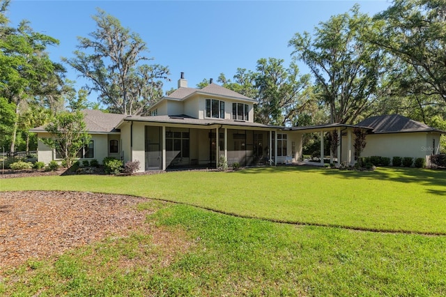14819 NW 21st Ave, Newberry, FL 32669 - back of house featuring a chimney, a sunroom, stucco siding, and a lawn