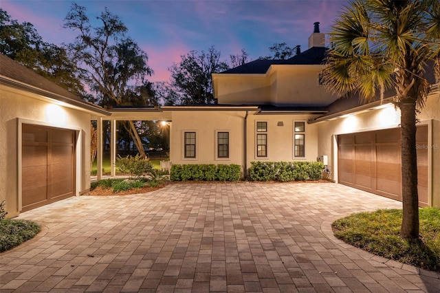 14819 NW 21st Ave, Newberry, FL 32669 - view of front of house with an attached garage, stucco siding, and decorative driveway