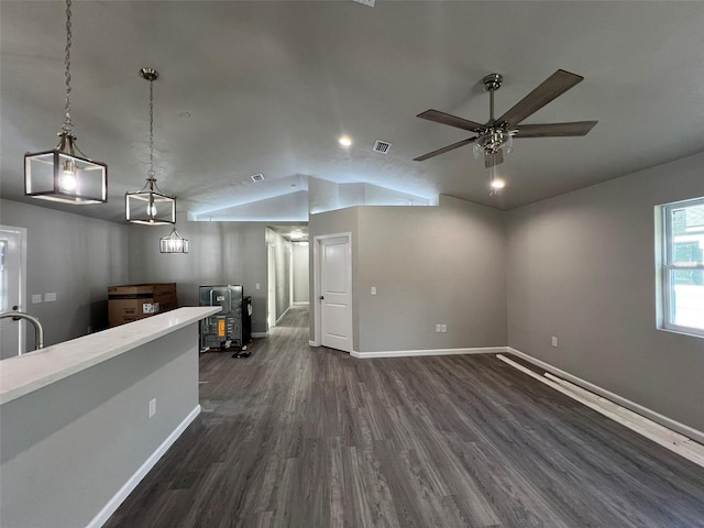 living area with dark wood finished floors, vaulted ceiling, baseboards, visible vents, and ceiling fan