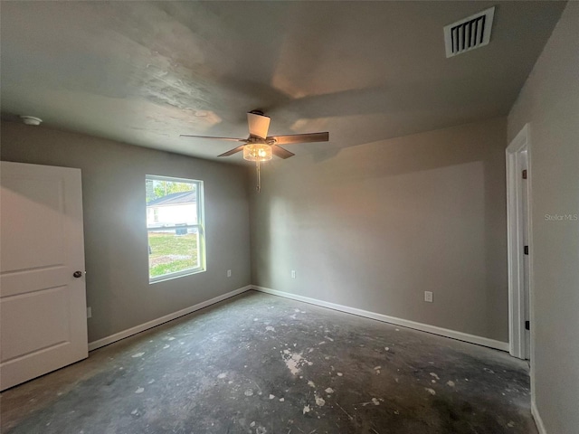 empty room with concrete floors, baseboards, a ceiling fan, and visible vents