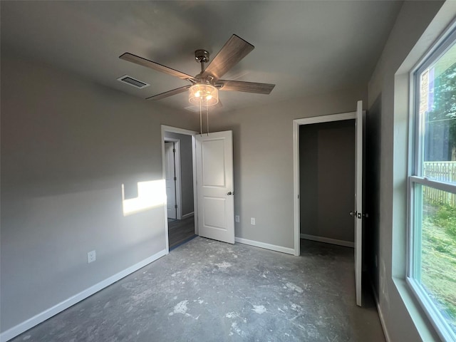 unfurnished bedroom featuring unfinished concrete flooring, baseboards, ceiling fan, and visible vents