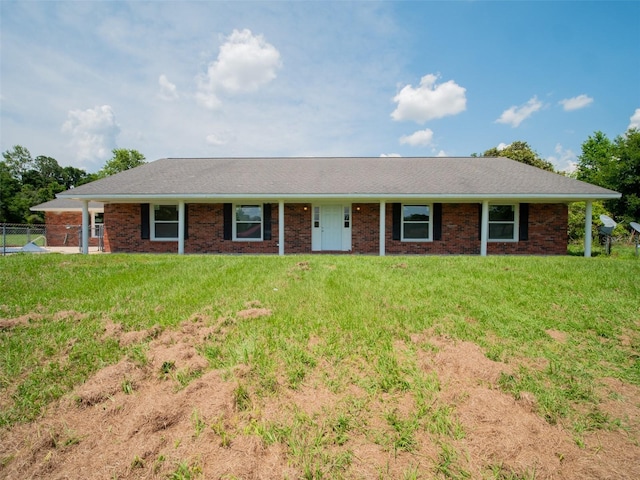 ranch-style house featuring brick siding, fence, and a front yard