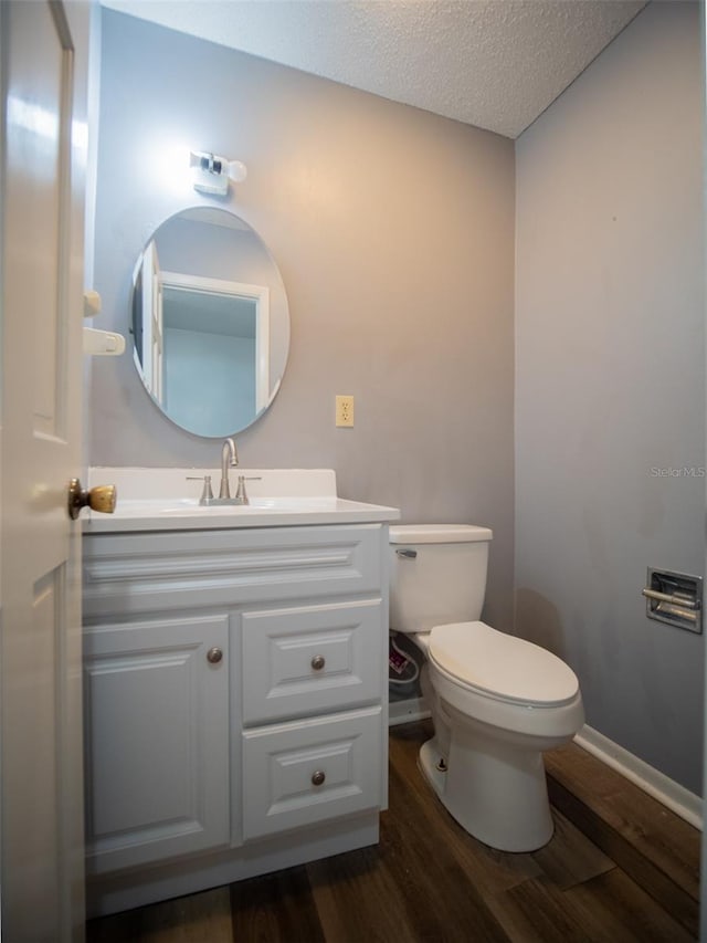 bathroom featuring vanity, a textured ceiling, wood finished floors, and toilet