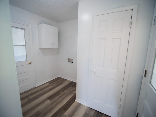 laundry room featuring cabinet space, dark wood-style flooring, hookup for a washing machine, a textured ceiling, and baseboards