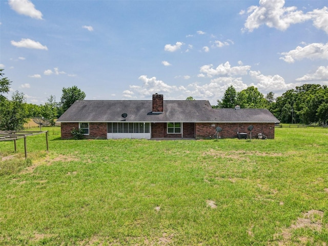rear view of property with a yard, fence, and a chimney