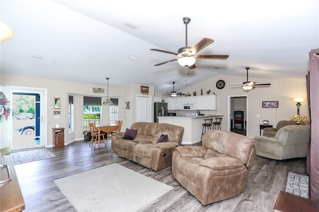 living room with a ceiling fan, wood finished floors, baseboards, lofted ceiling, and visible vents