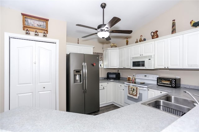 kitchen with white cabinets, light countertops, a sink, white appliances, and ceiling fan